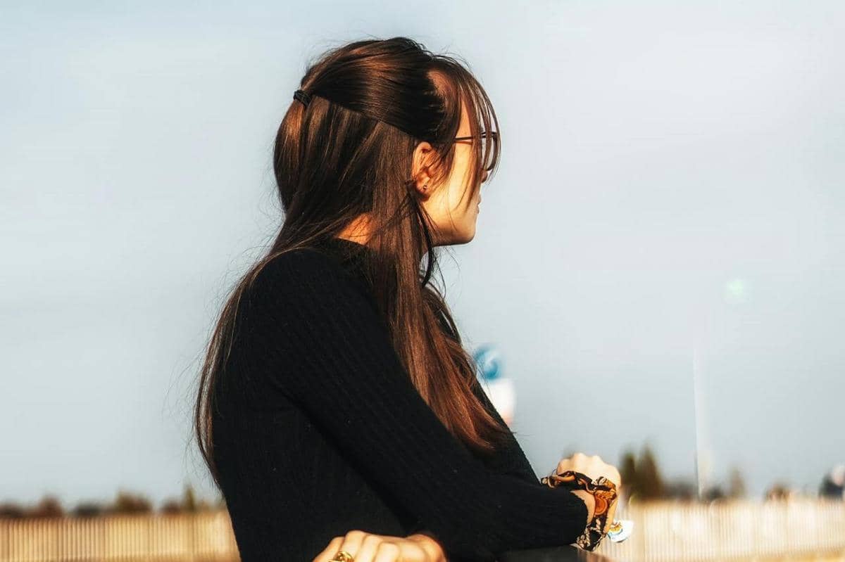 Wanita berdiri melihat pemandangan.