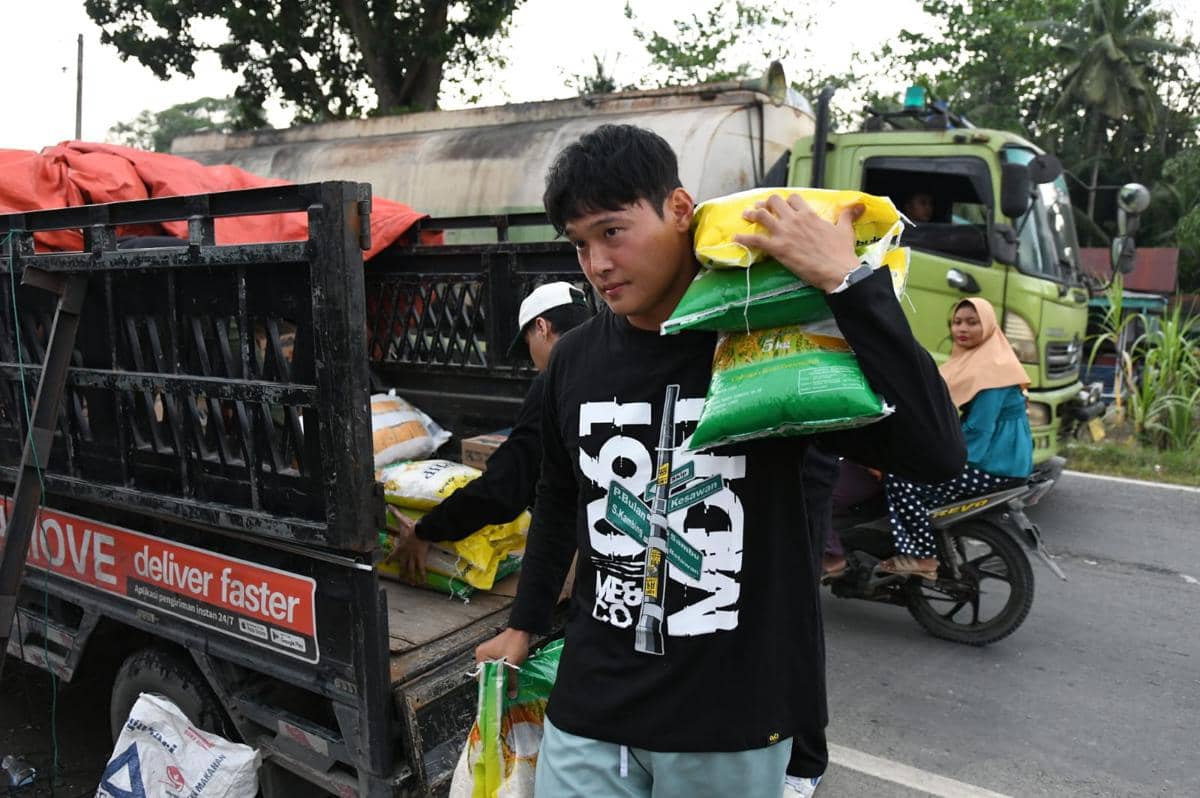 Kapten PSMS Kim Jeung-ho memanggul beras bantuan untuk korban banjir Langkat (dok.PSMS)