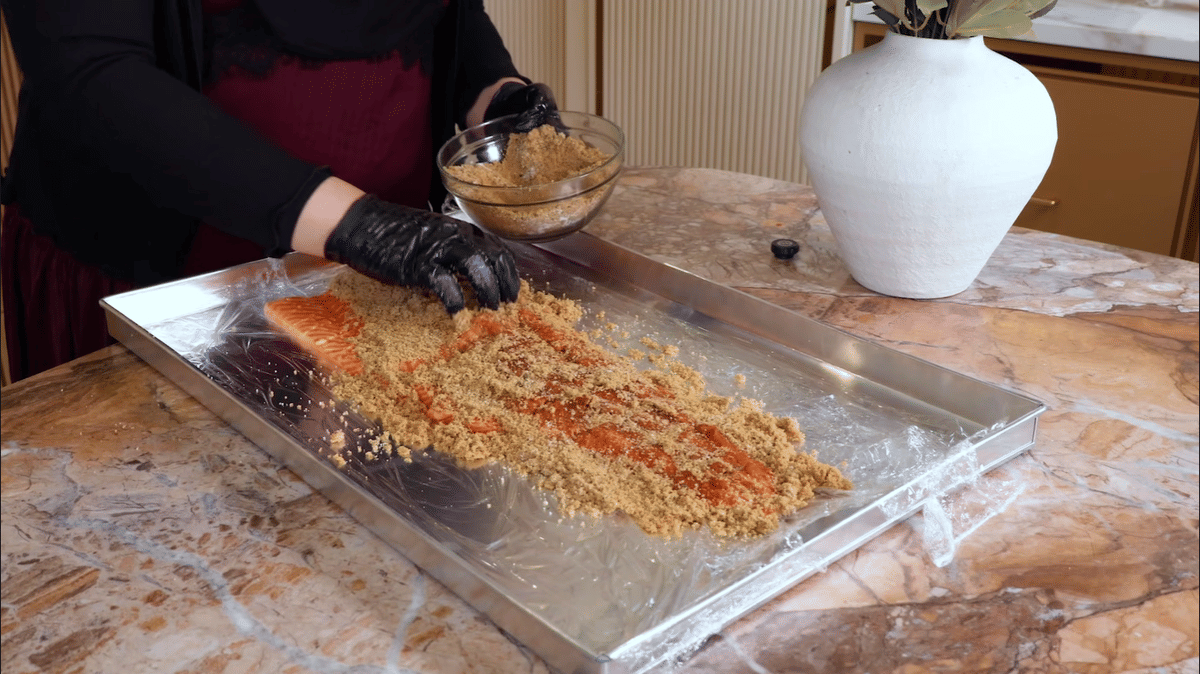 Potret Tasyi melumuri salmon dengan bahan-bahan untuk curing