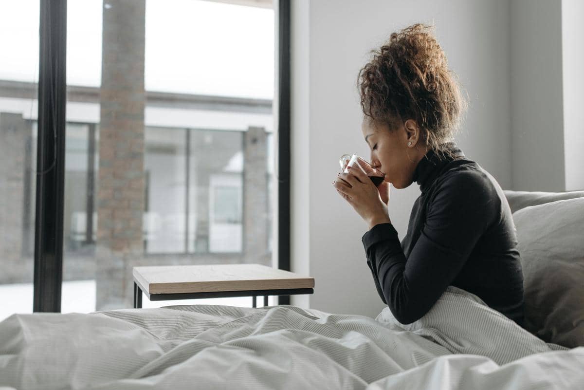 Seorang perempuan hamil menikmati teh hangat.