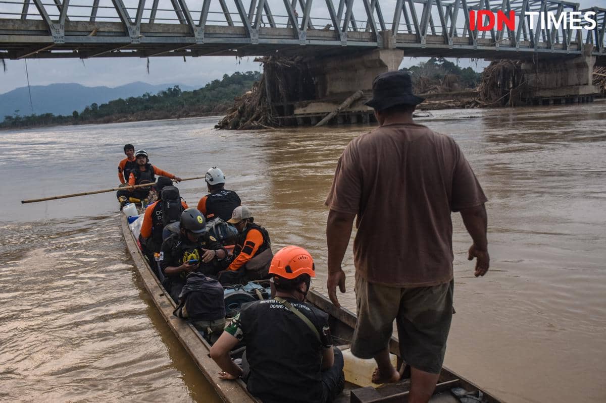 Para relawan Relawam Disaster Management Center (DMC) Dompet Dhuafa membawa logistik melalui jalur sungai menuju Desa Sekumur, Kecamatan Sekerak, Kabupaten Aceh Tamiang, Aceh, Rabu (10/12/2025). (IDN Times/Prayugo Utomo)