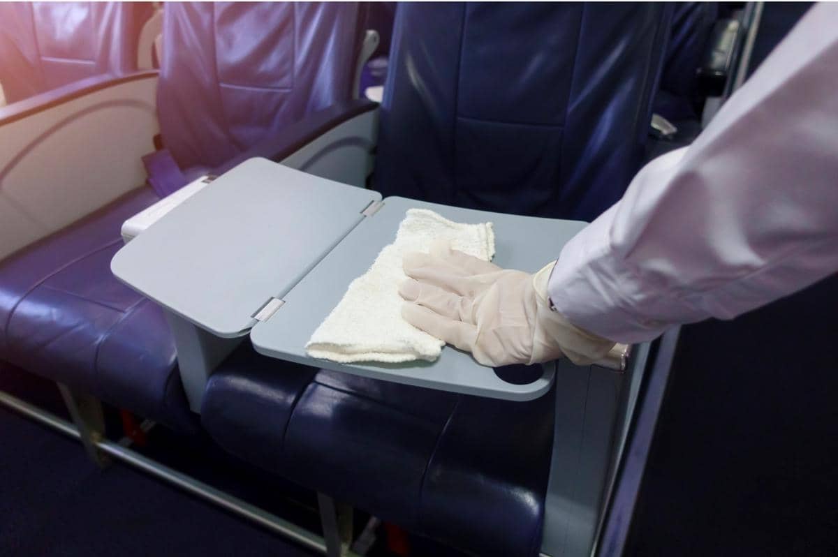 ilustrasi membersihkan meja lipat di pesawat