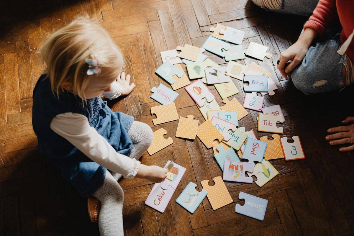 Photo by Karola G: https://www.pexels.com/photo/girl-playing-puzzle-game-on-brown-wooden-floor-7296379/