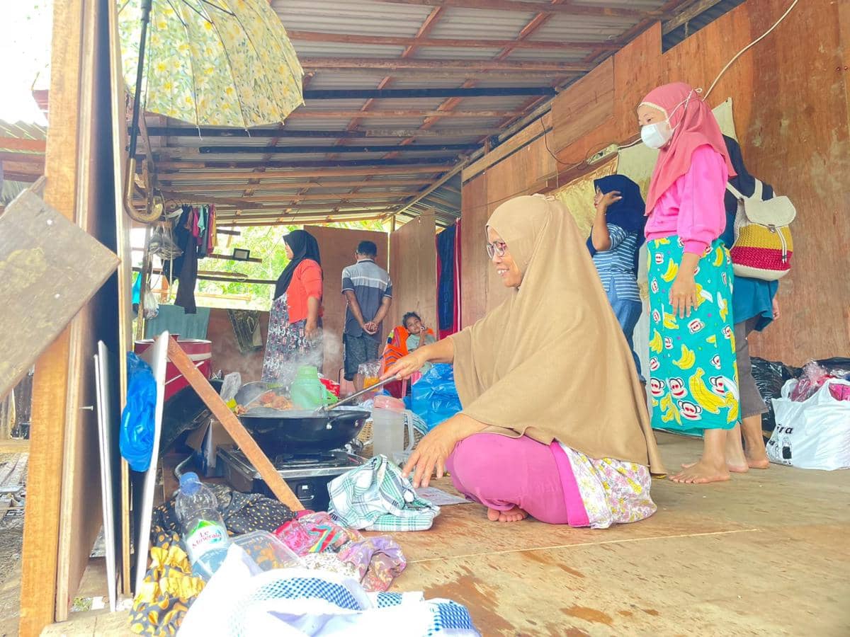 Seorang warga memasak di Huntara yang dibuat secara mandiri