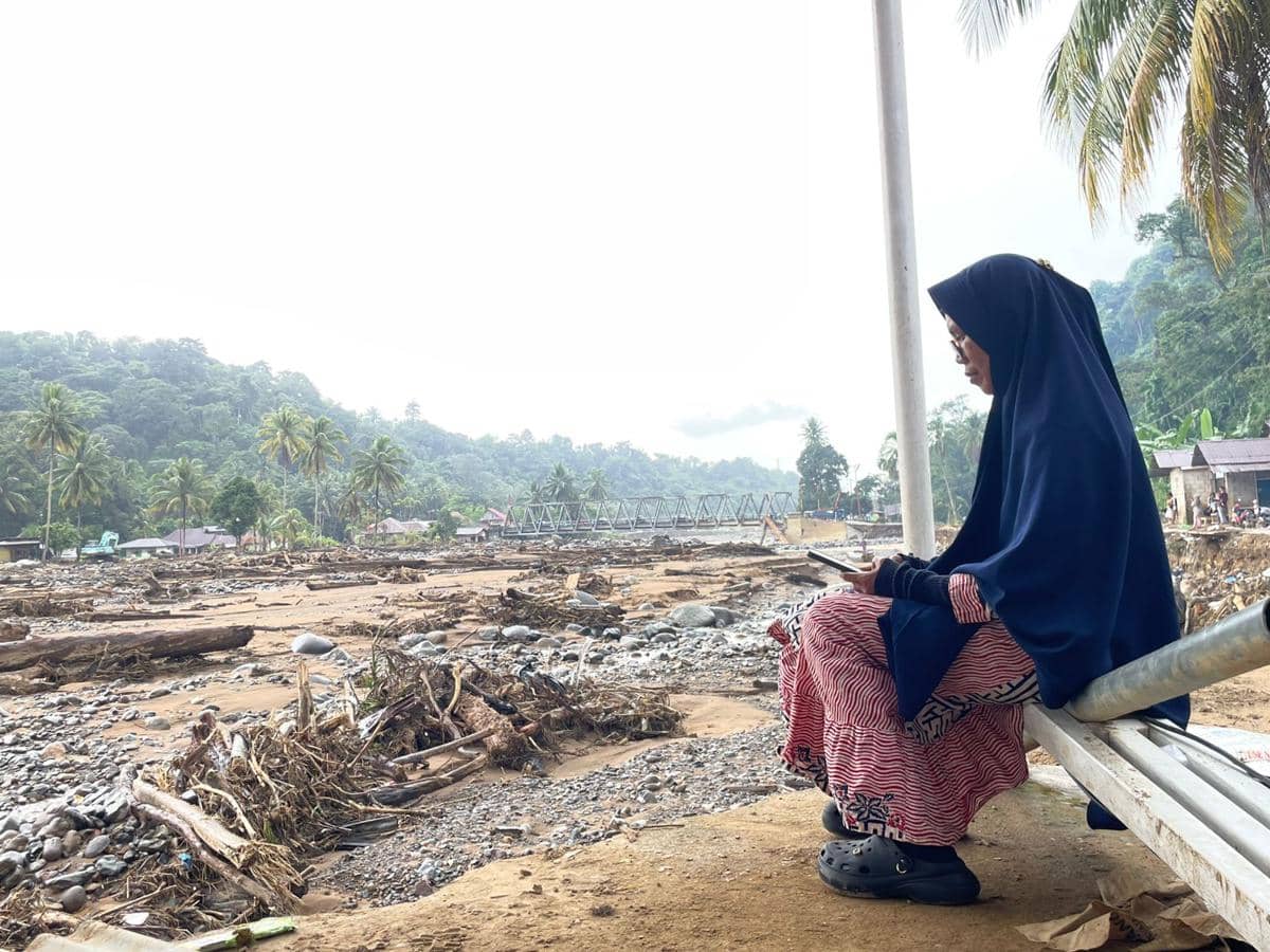 Seorang warga di Batu Busuk, Padang mengabarkan keluarganya terkait keadaan terbaru di tempat tinggalnya (Foto: IDN Times/Halbert Caniago)