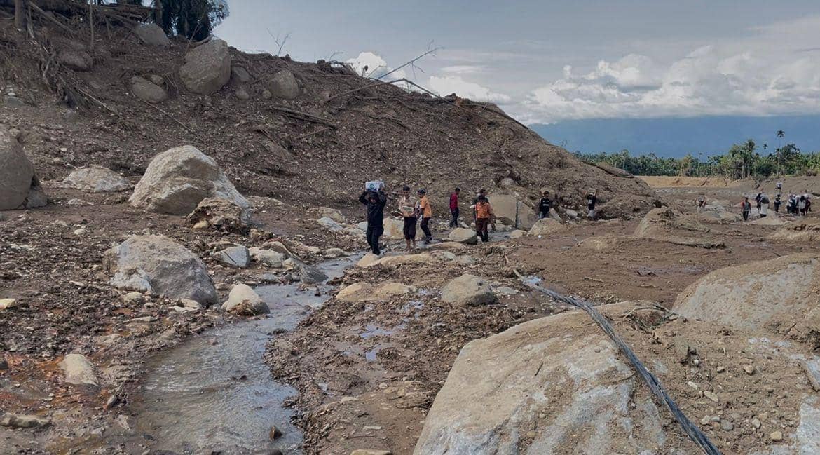 Warga di daerah Palembayan, Kabupaten Agam mengangkut bantuan yang diberikan oleh para dermawan