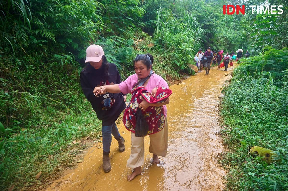 Seorang relawan anak muda membantu mengevakuasi warga yang terdampak dan menjadi korban bencana tanah longsor di Pekalongan, Jawa Tengah, Rabu (22/1/2025). Aksi gotong royong tersebut mencerminkan semangat demokrasi substantif yang hidup, di mana kepedulian sosial dan kemanusiaan terhadap sesama menjadi tanggung jawab bersama. (IDN Times/Dhana Kencana)