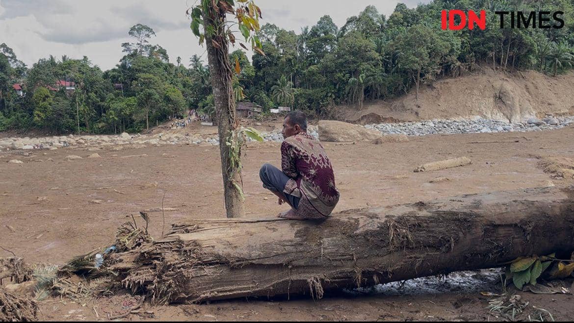 Seorang pria di daerah Palembayan, Kabupaten Agam menatap puing-puing yang diakibatkan banjir bandang dan menimbun 9 anggota keluarganya (Foto: IDN Times/Halbert Caniago)