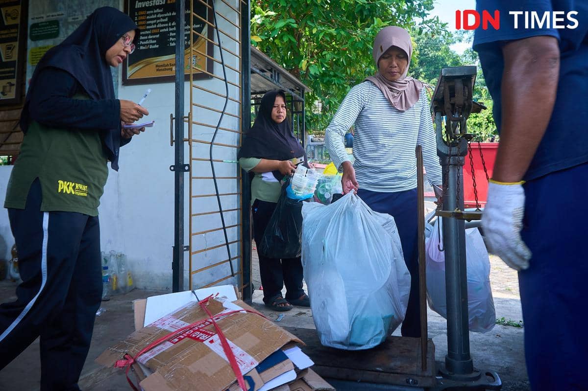 Sejumlah ibu rumah tangga menimbang sampah rumah tangga yang sudah dipilah di bank sampah Ngudi Lestari di Kota Semarang, Minggu (28/9/2025). Konsistensi para ibu dalam memisahkan sampah organik dan anorganik ini merupakan benteng pertahanan pertama untuk mencegah pencemaran lingkungan, membuktikan bahwa aksi konservasi besar selalu dimulai dari kebiasaan kecil sehari-hari. (IDN Times/Dhana Kencana)