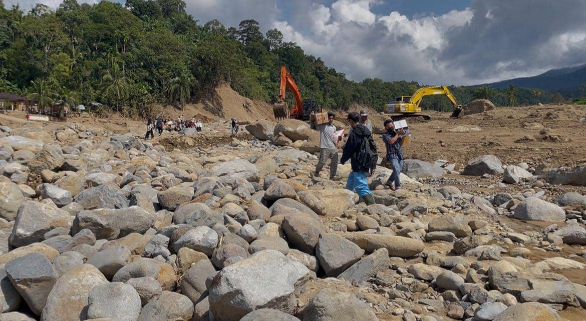 Warga di daerah Palembayan, Kabupaten Agam mengangkut bantuan yang diberikan oleh para dermawan