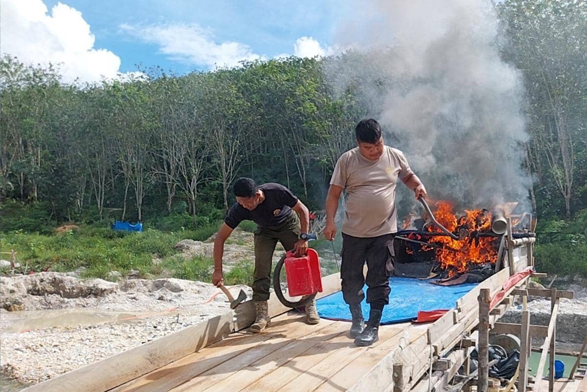 Tim Gabungan saat menindak dan memusnahkan puluhan rakit PETI di area kebun karet milik Pemkab Kuansing (IDN Times/ dok Polres Kuansing)