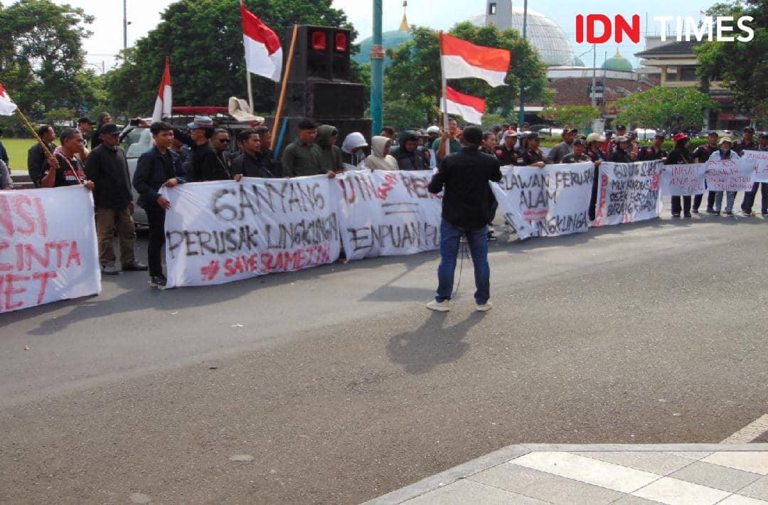 Pendemo kritisi Ketika rakyat menjerit, pemerintah berlindung di balik prosedur dan stempel izin, Jumat (19/12/2025).(IDN Times/Cokie Sutrisno)