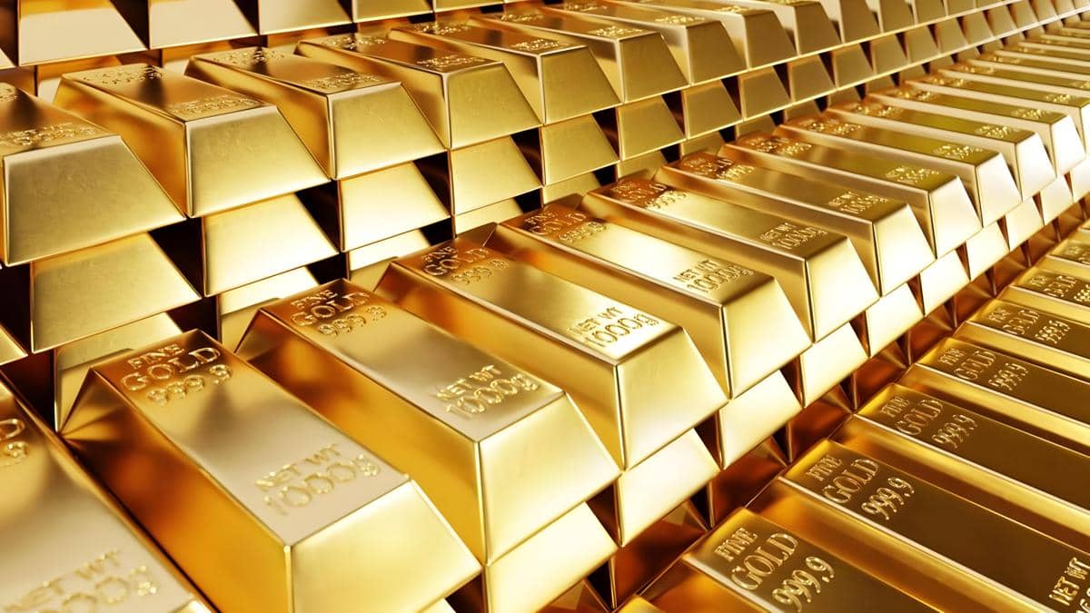 Barisan emas batangan berkilau dengan ukiran "Fine Gold 999.9" dan berat "1000g" yang disusun bertingkat