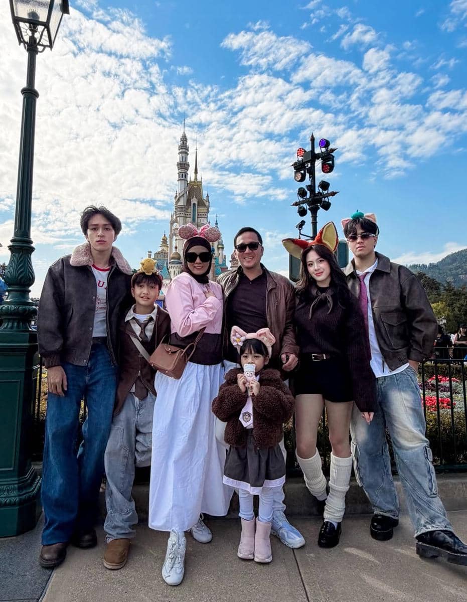 Azizi Asadel liburan ke Disneyland Hong Kong.