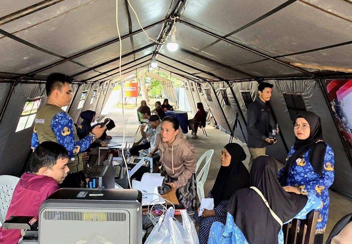 Seorang petugas Disdukcapil Padang memberikan KTP warga terdampak bencana di Huntara (Dokumentasi Diskominfo Padang)