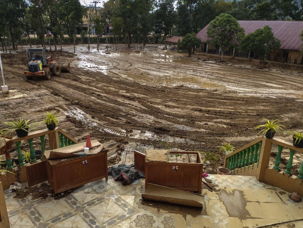 Alat berat melakukan pembersihan lumpur yang mengendap di halaman SMA Swasta ST Fransiskus, Kecamatan Pandan, Kabupaten Tapanuli Tengah, Sabtu (20/12/2025). (IDN Times/Prayugo Utomo)