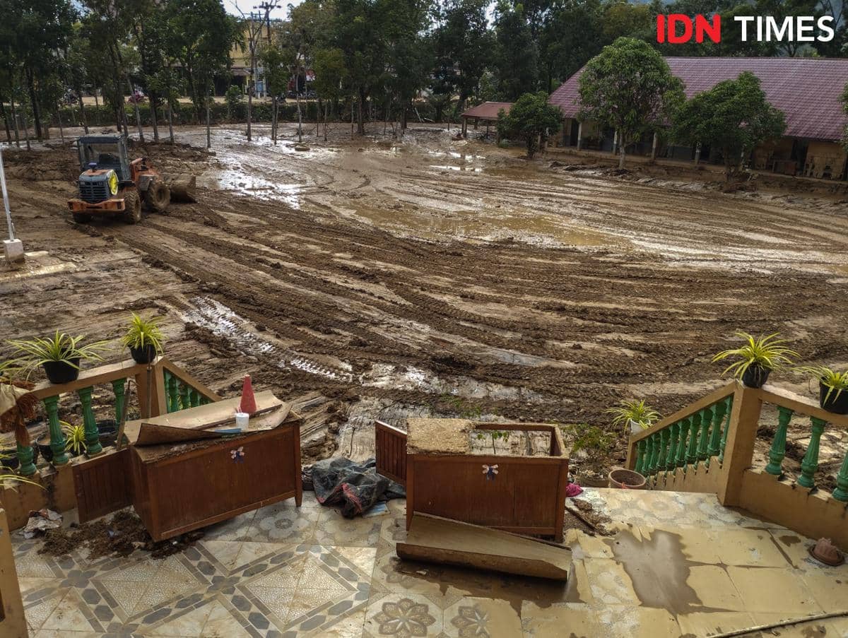 Alat berat melakukan pembersihan lumpur yang mengendap di halaman SMA Swasta ST Fransiskus, Kecamatan Pandan, Kabupaten Tapanuli Tengah, Sabtu (20/12/2025). (IDN Times/Prayugo Utomo)