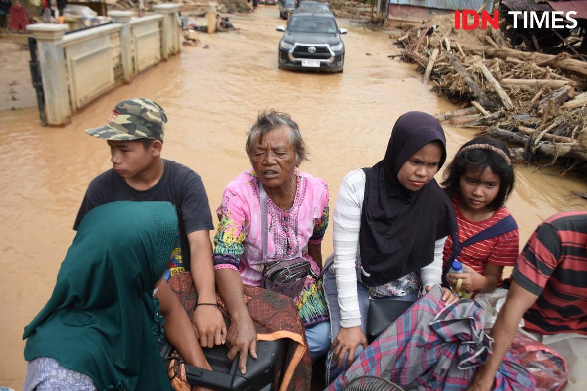 Warga menumpang mobil kabin ganda berpenggerak empat roda saat hendak ke luar dari kawasan Desa Hutanobolon, Kecamatan Tukka, Kabupaten Tapanuli Tengah, Jumat (19/12/2025). (IDN Times/Prayugo Utomo)