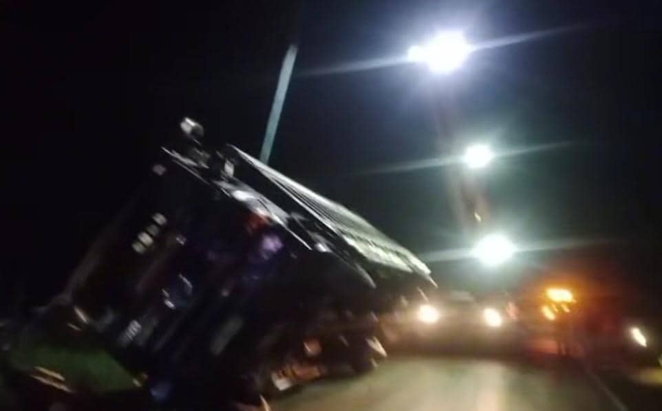 Proses evakuasi truk menggunakan alat berat.