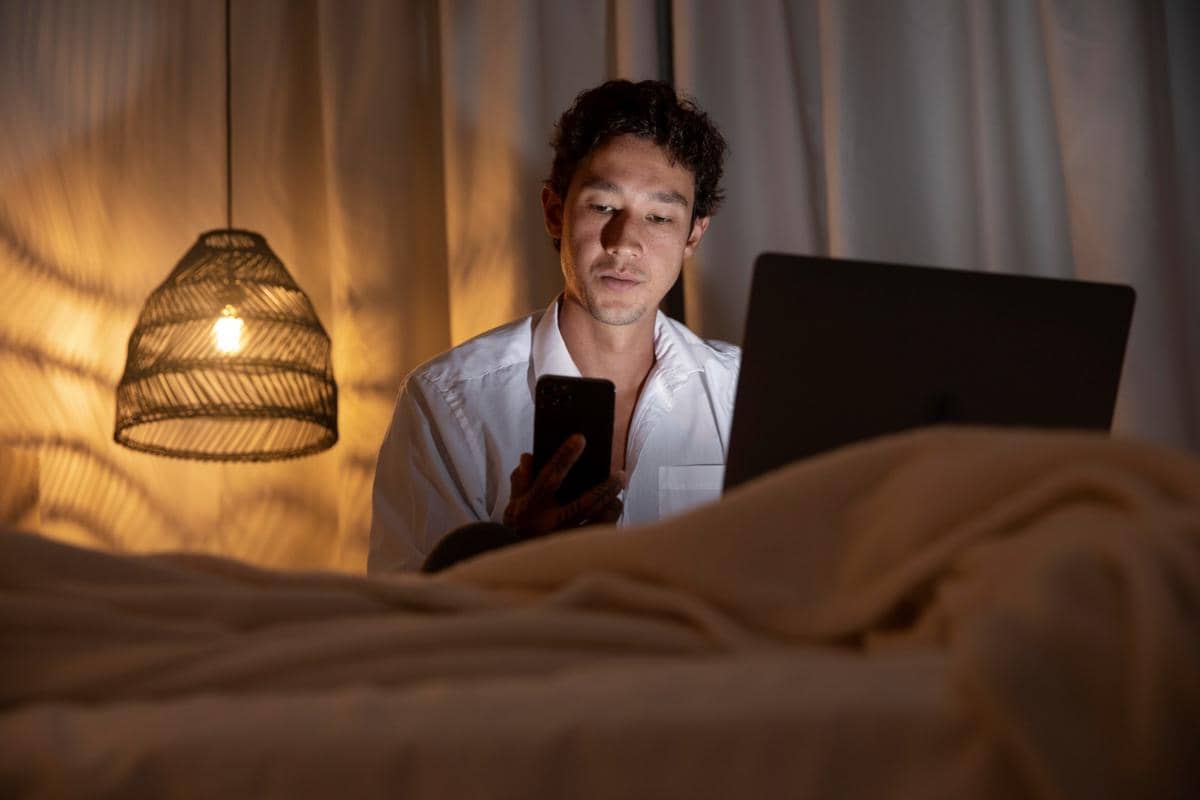 Ilustrasi perempuan bermain gadget di kamar tidur