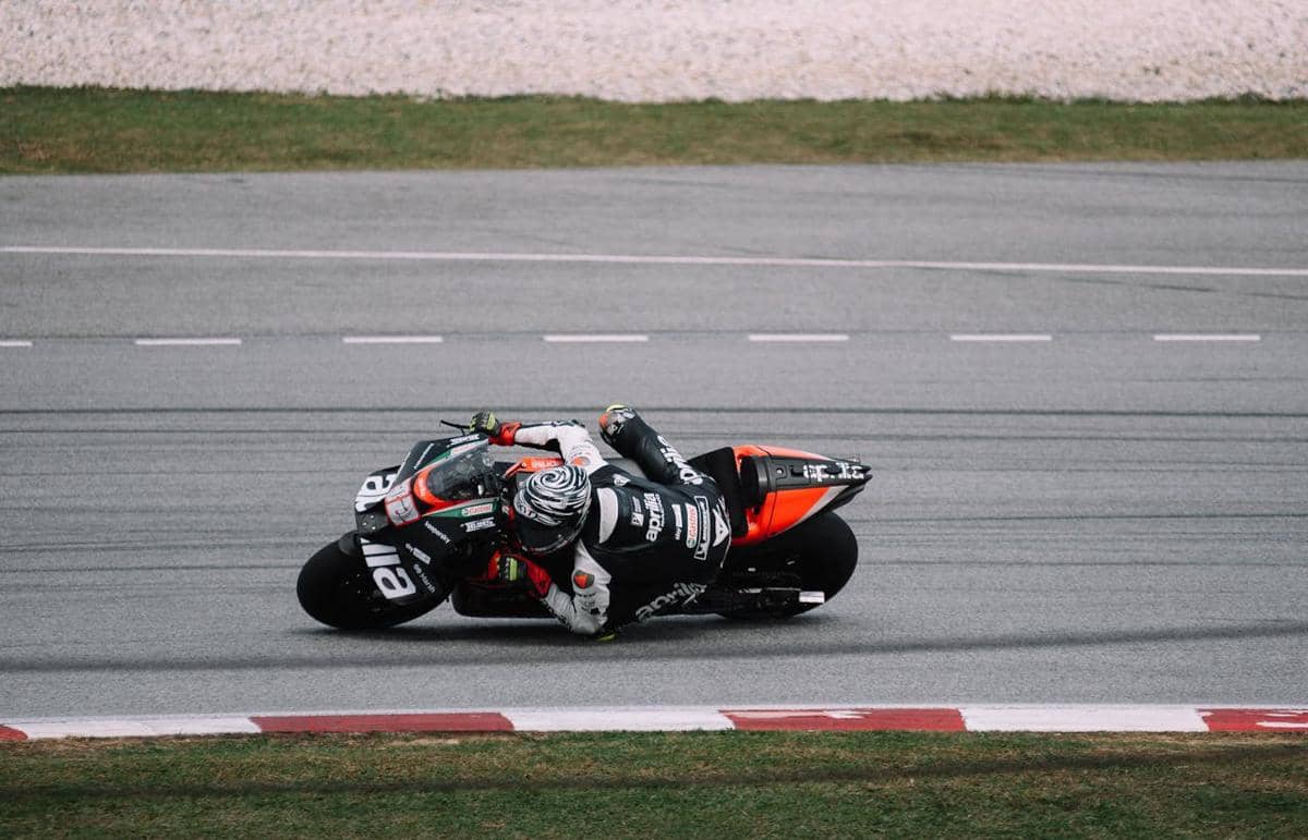 Pembalap MotoGP Aprilia sedang melaju di trek balap.