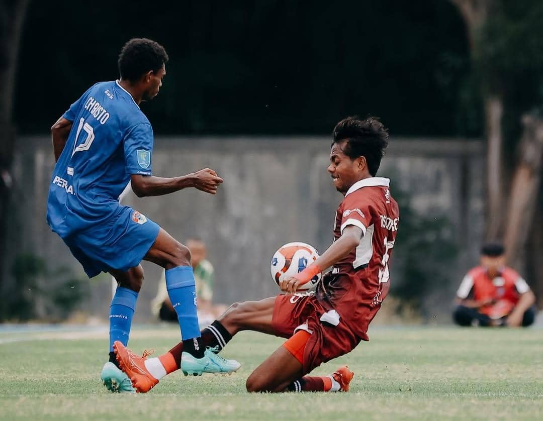 Pemain Perseden Denpasar (merah) dihadang pemain Persebata Lembata (biru).