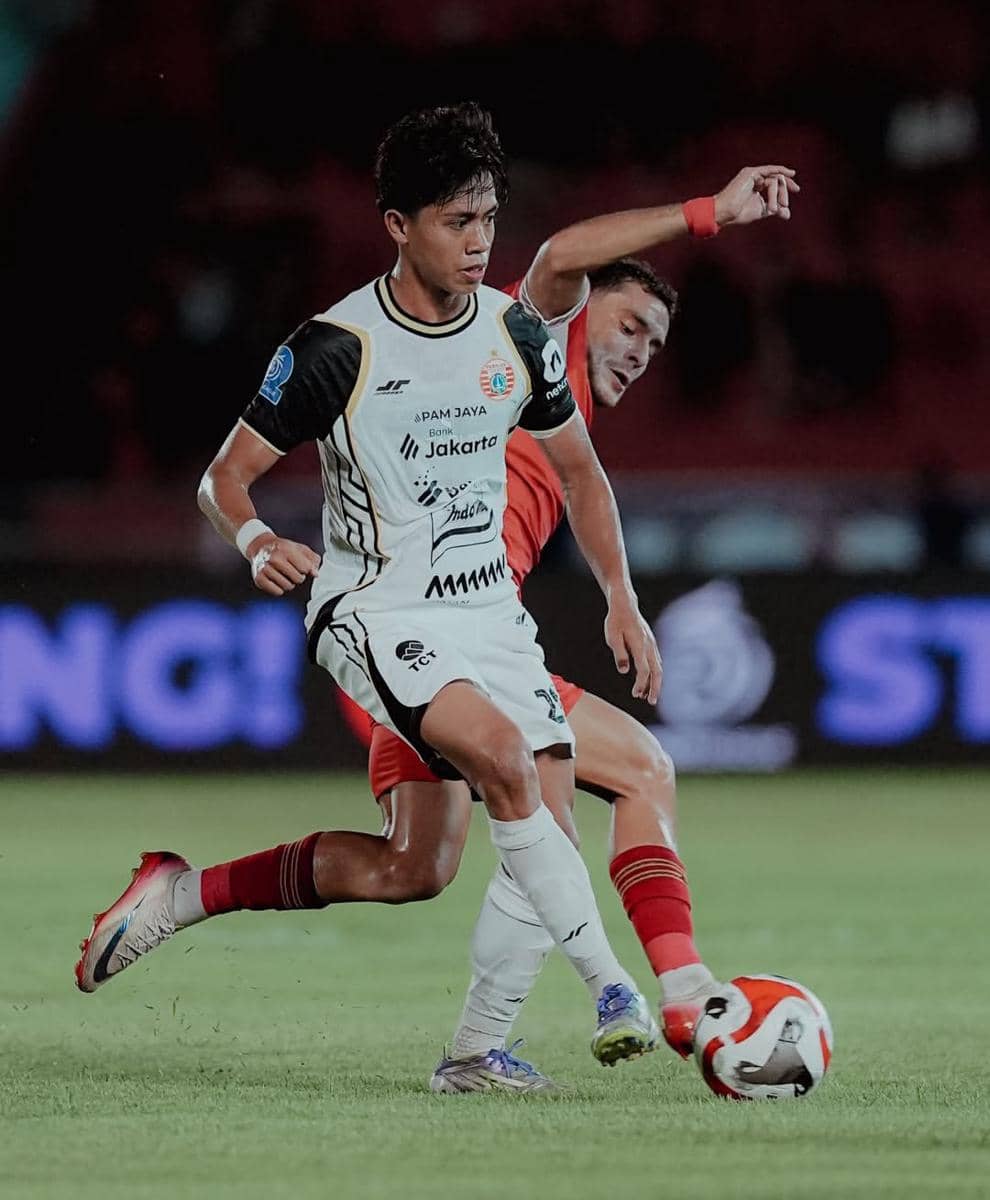 Dua pemain dari masing-masing tim sedang berduel di lapangan