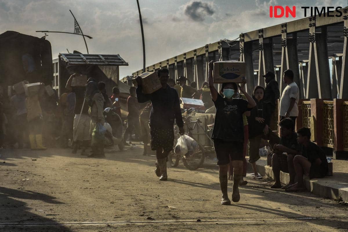 Para penyintas mengambil bantuan logistik dari para relawan di Jembatan Kuala Simpang, Kabupaten Aceh Tamiang