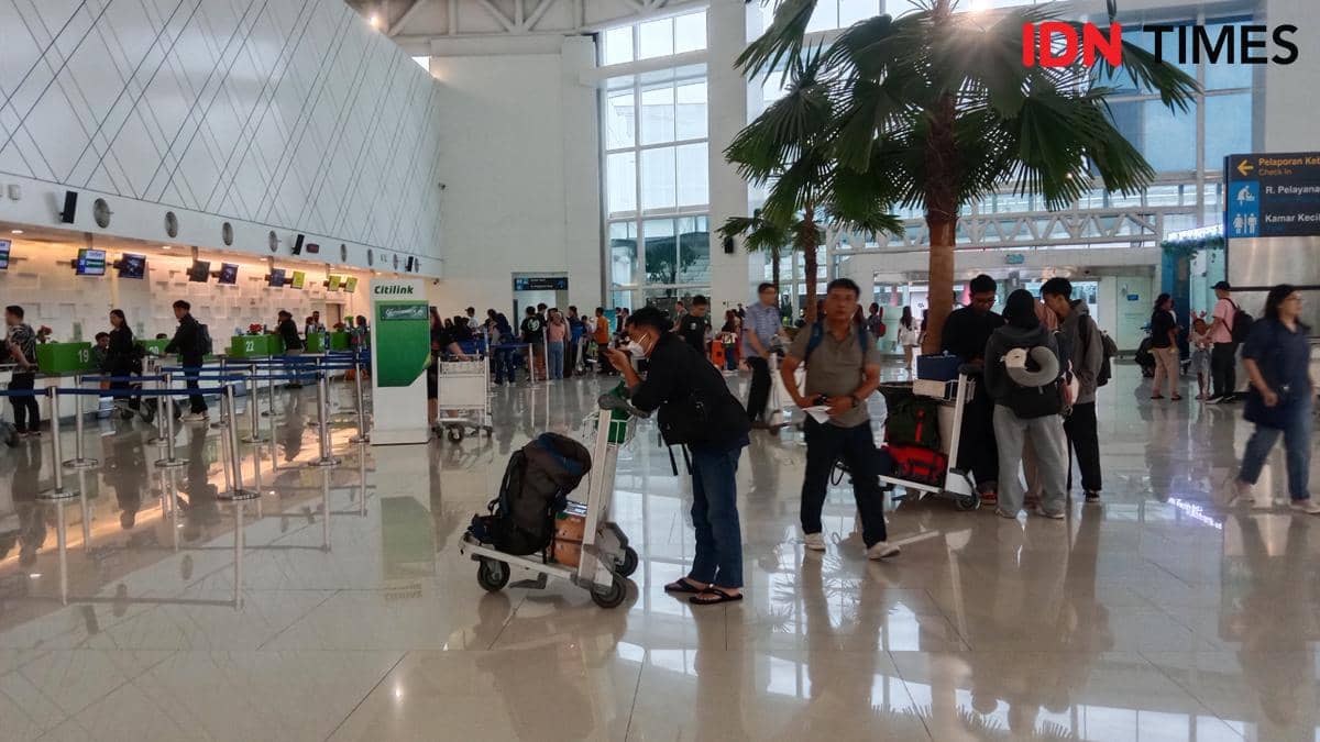 Seorang pria menunggu troli barangnya di Bandara Ahmad Yani Semarang. (IDN Times/Fariz Fardianto)