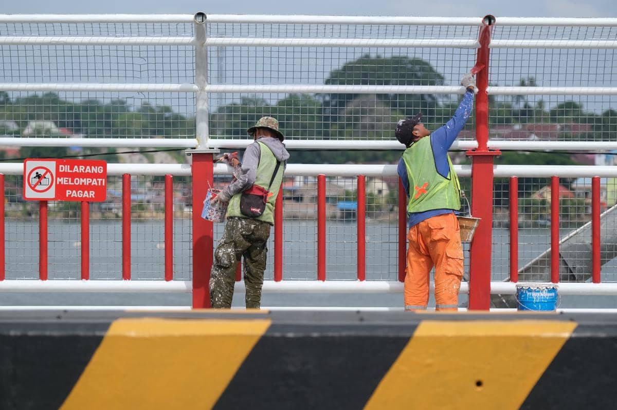 Ilustrasi pekerja menyelesaikan pengecatan pagar pengaman di jembatan utama. (ANTARA FOTO/Andry Denisah)