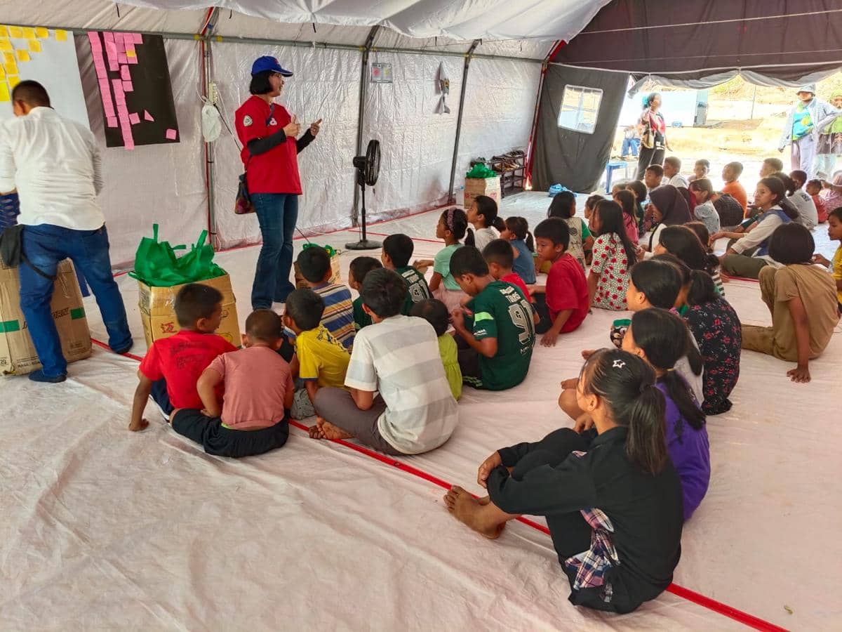 Pemimpin Redaksi IDN Times, Uni Lubis memberikan bingkisan untuk anak-anak di Posko Pengungsian Hutanabolon, Kecamatan Tukka, Tapanuli Tengah, Rabu (24/12/2025). (IDN Times/Arifin Al Alamudi)