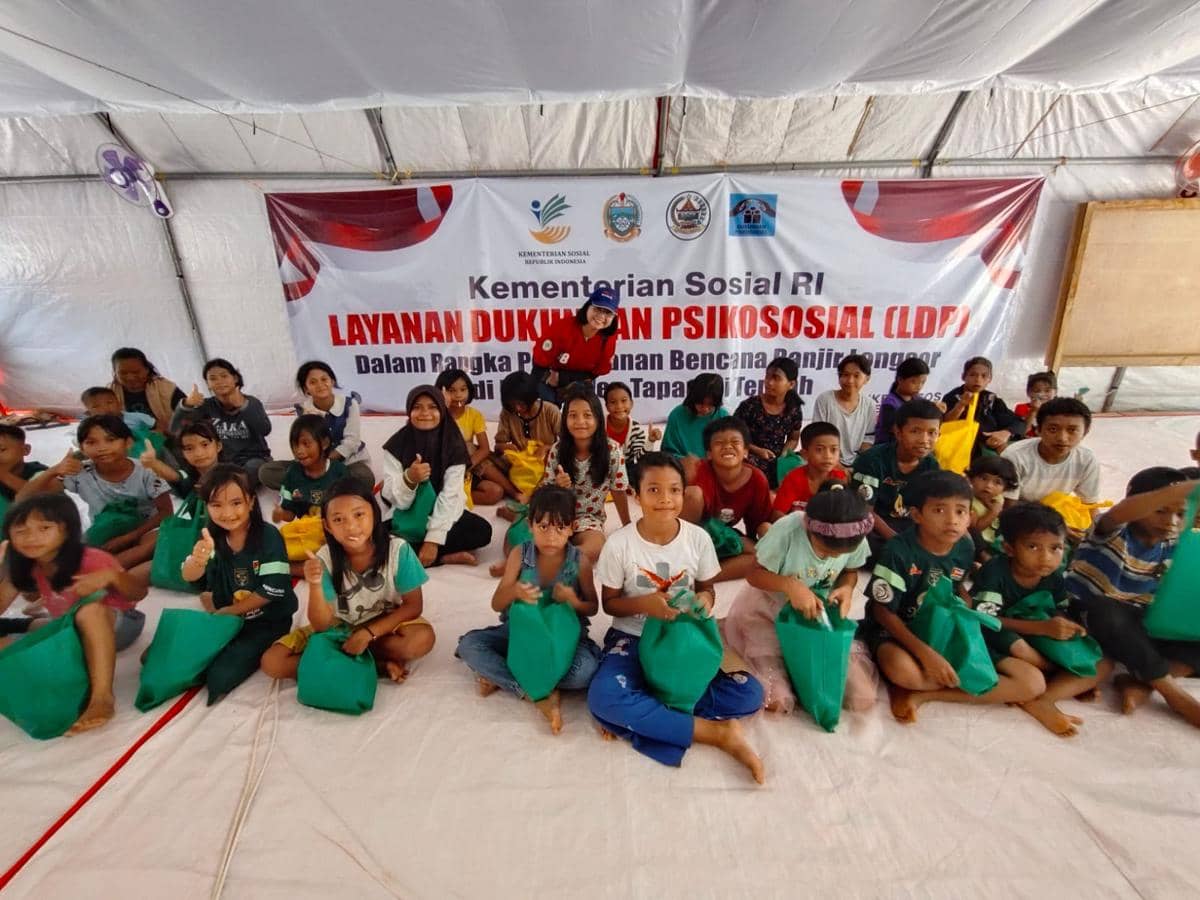 Pemimpin Redaksi IDN Times, Uni Lubis memberikan bingkisan untuk anak-anak di Posko Pengungsian Hutanabolon, Kecamatan Tukka, Tapanuli Tengah, Rabu (24/12/2025). (IDN Times/Arifin Al Alamudi)