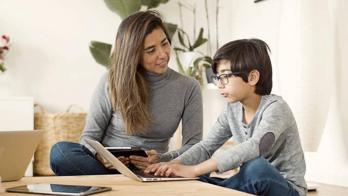 Ilustrasi anak belajar menggunakan laptop dengan orang tua mendampingi.