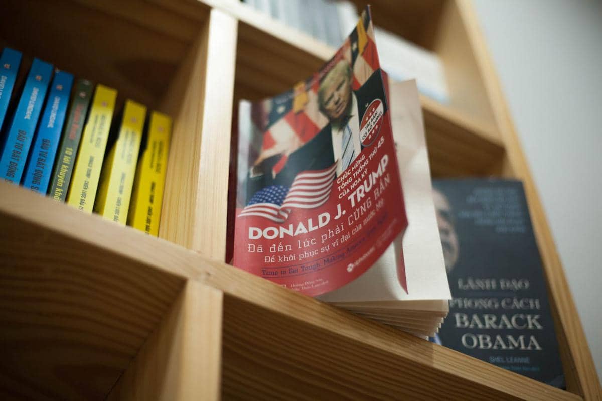 Buku tentang Donald Trump berada di rak buku.