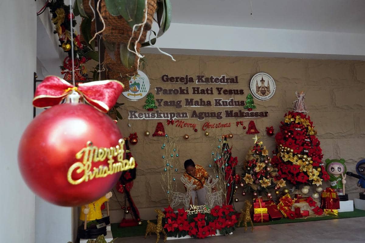 Panitia memasang ornamen natal di Gereja Katedral Makassar, Sulawesi Selatan, Selasa (23/12/2025). Sejumlah persiapan seperti pemasangan dekorasi dan pembersihan dilakukan di gereja tersebut untuk memberi kenyamanan bagi umat kristiani yang akan mengikuti misa malam Natal dan misa hari Natal. (ANTARA FOTO/Hasrul Said)