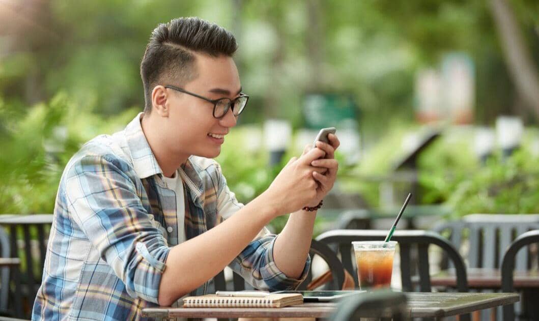 Ilustrasi seseorang memakai smartphone sebagai perangkat untuk mengakses berbagai aktivitas digital sehari-hari.