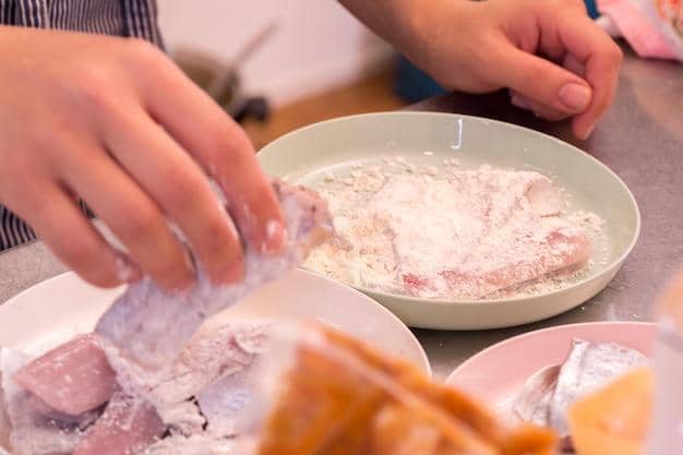 Potret seseorang  membalut daging dengan tepung