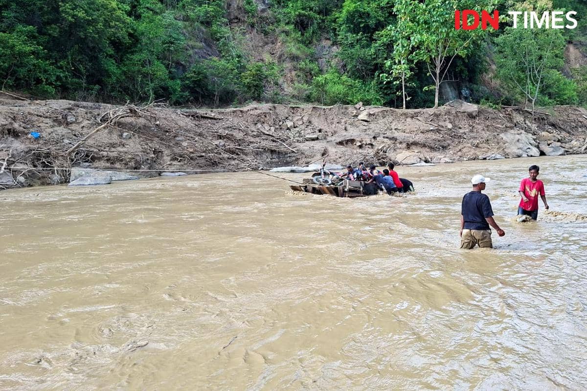 Warga Mukim Jamat menyeberang menggunakan getek karena jembatan darurat putus (IDN Times/Muhammad Saifullah)