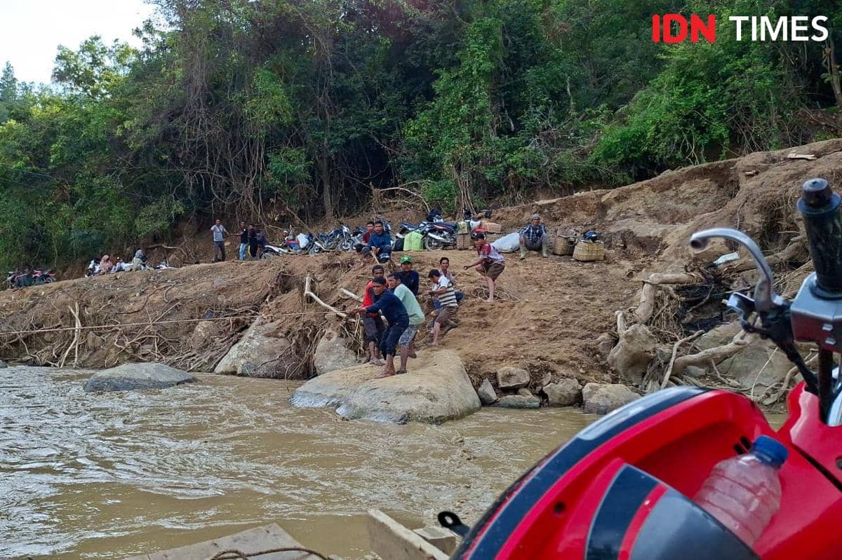 Warga Mukim Jamat menyeberang menggunakan getek karena jembatan darurat putus (IDN Times/Muhammad Saifullah)