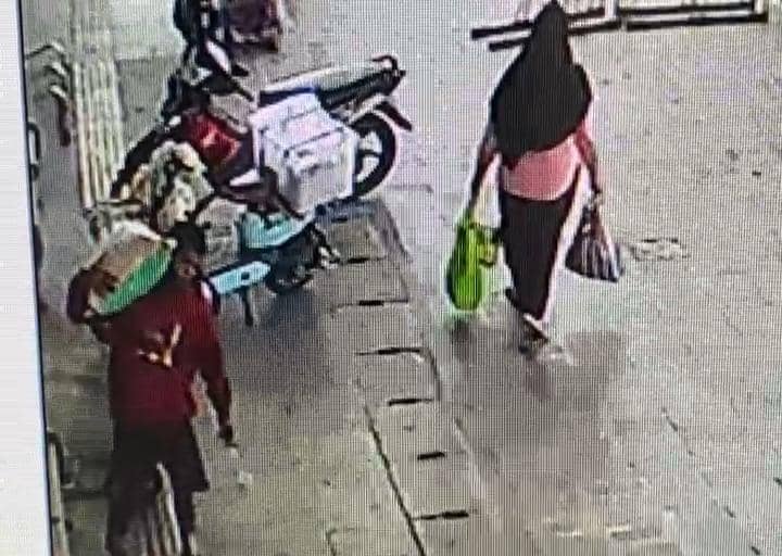 Seorang pria berbaju merah nekat menyamar sebagai kuli panggul demi membawa kabur satu karung beras di pasar besar Ngawi. IDN Times/Istimewa.