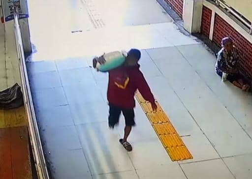 Seorang pria berbaju merah nekat menyamar sebagai kuli panggul demi membawa kabur satu karung beras di pasar besar Ngawi. IDN Times/Istimewa.