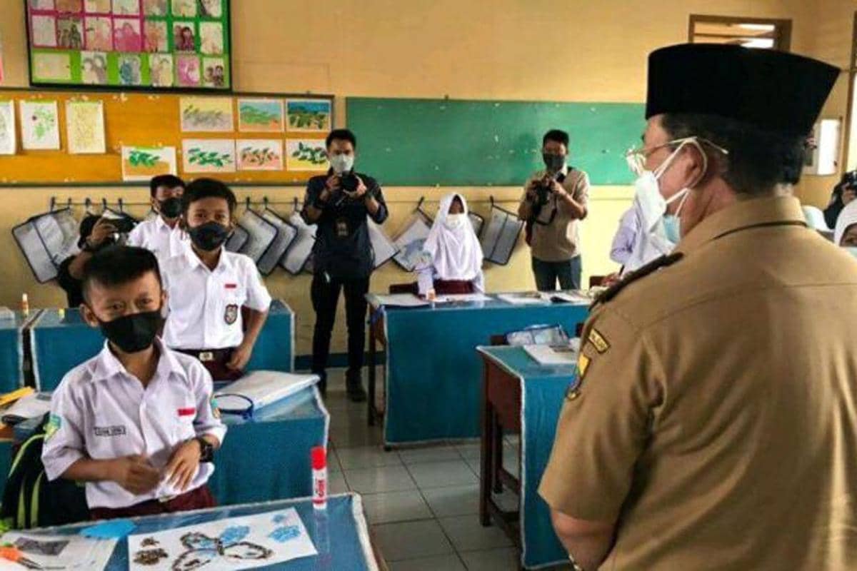 Guru dan siswa sekolah dasar sedang melaksanakan kegiatan pembelajaran di dalam kelas.