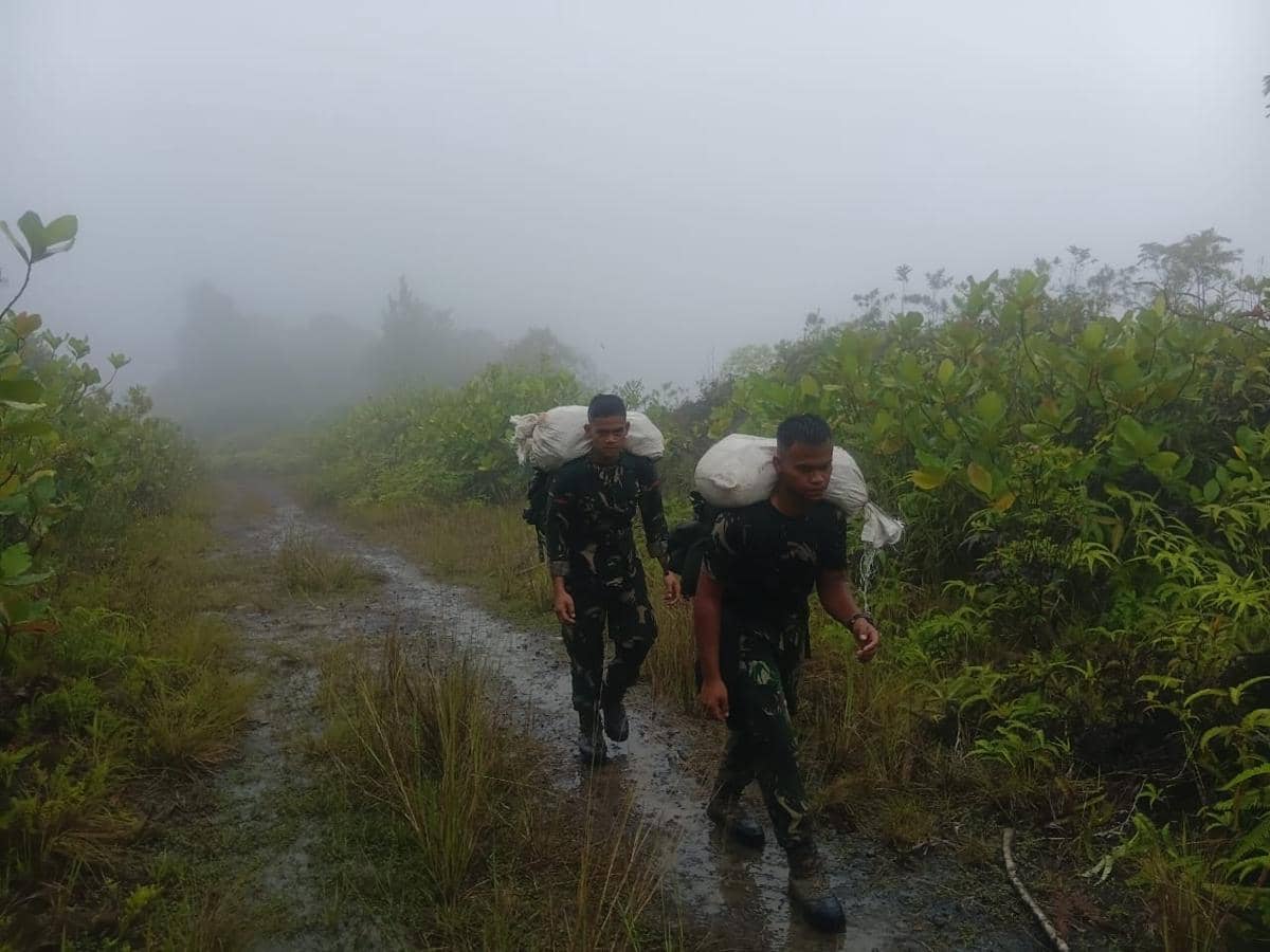 Prajurit TNI AD berjalan kaki menyalurkan bantuan ke masyarakat di Dusun I Desa Simaningir, Tapanuli Tengah (Dok. Dispenad)