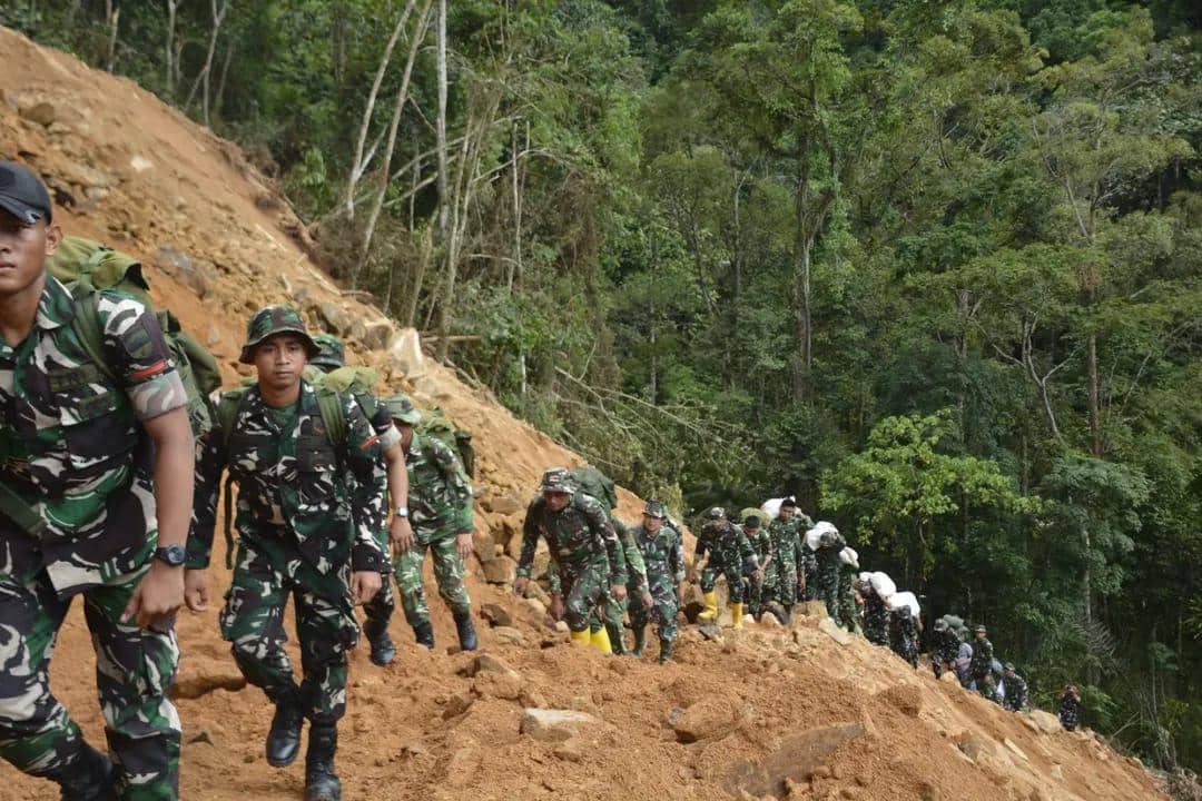 Prajurit TNI AD berjalan kaki menyalurkan bantuan ke masyarakat di Dusun I Desa Simaningir, Tapanuli Tengah (Dok. Dispenad)