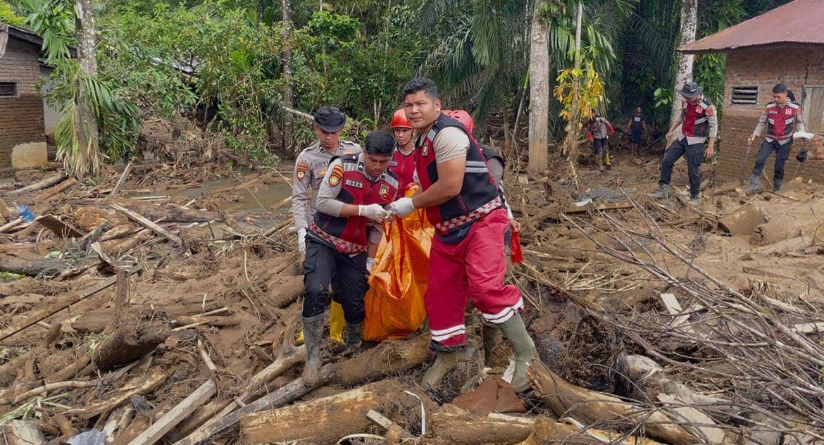 Personel Polri di daerah Kecamatan Palembayan mengangkat jenazah yang ditemukan di material banjir bandang