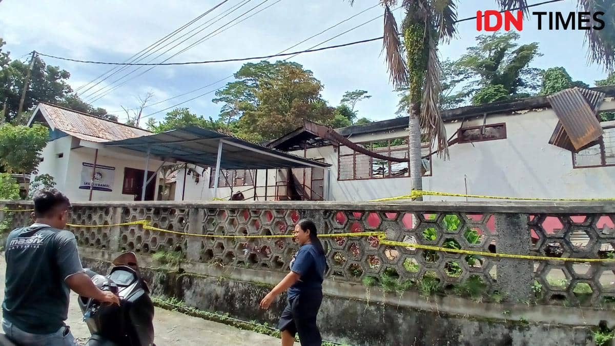 Warga melintasi TKP kebakaran Panti Wreda, Manado, Sulawesi Utara, Senin (29/12/2025). IDNT imes/Savi