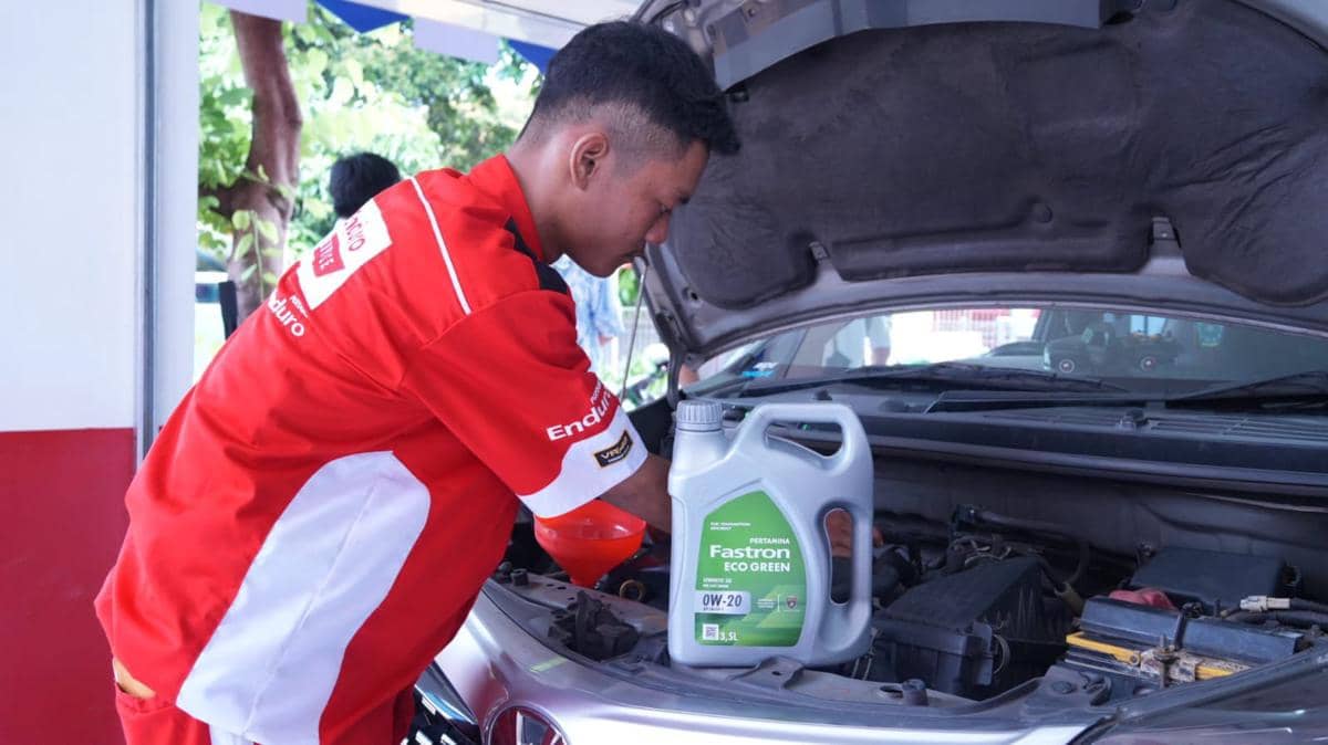 Petugas Enduro Service melayani penggantian oli mobil konsumen.jpeg