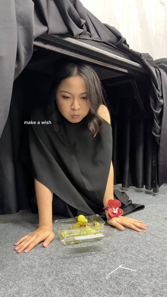 potret Bernadya makan anggur di bawah meja tahun baru