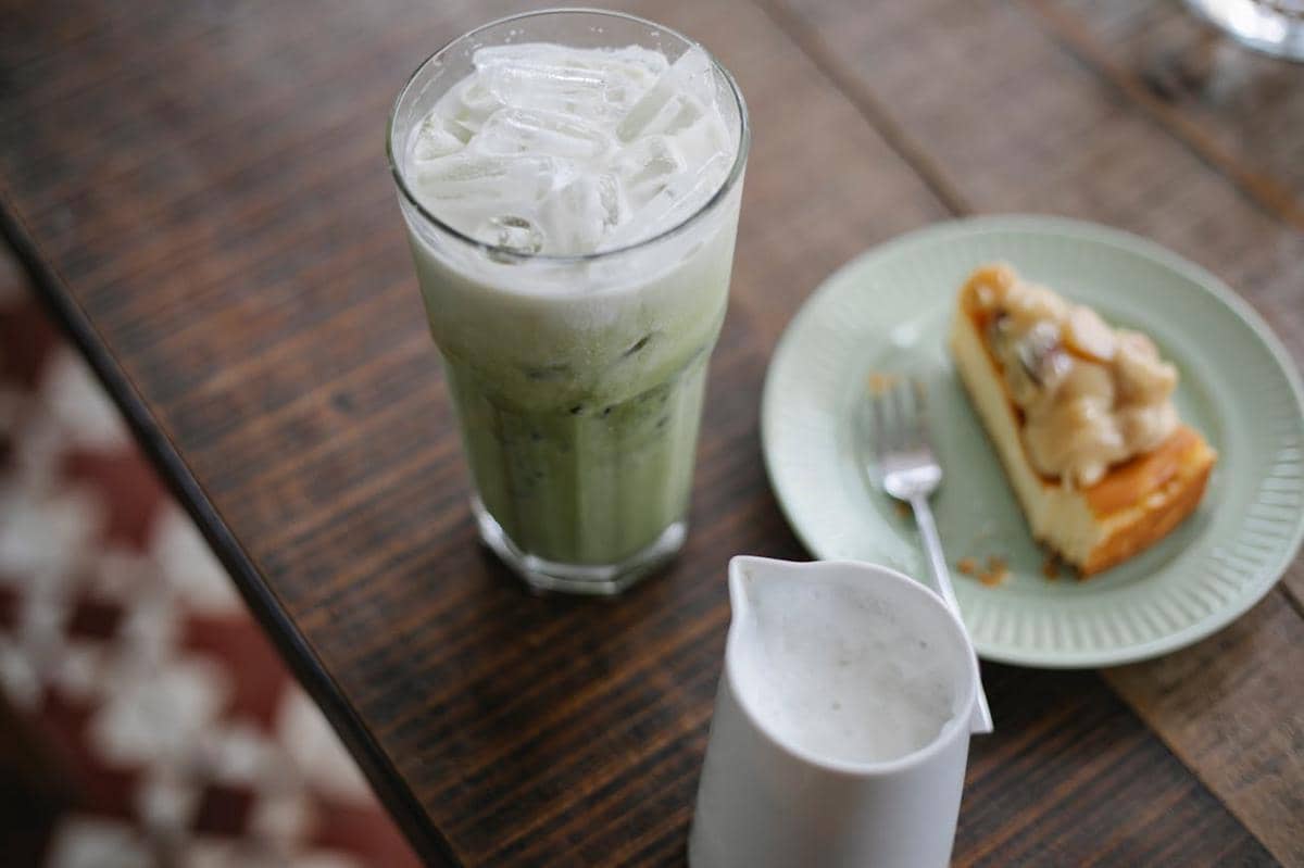 ilustrasi iced matcha latte yang disajikan dengan kue 