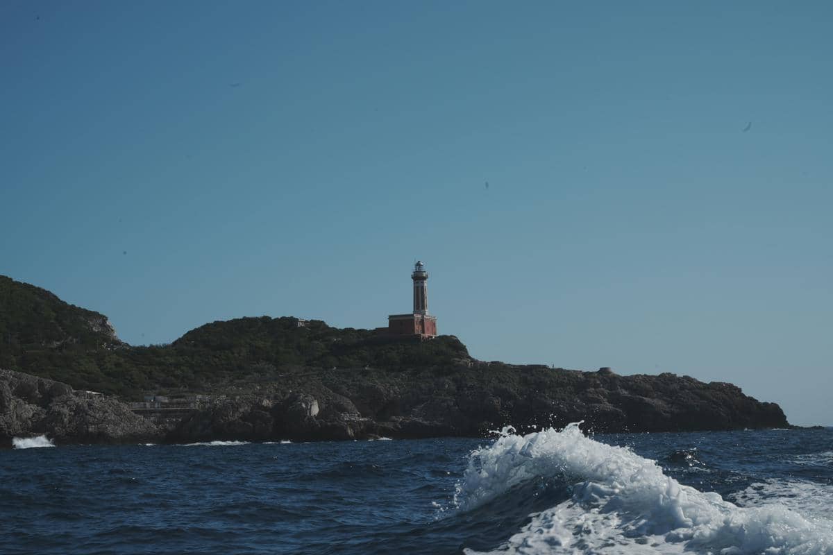 ilustrasi sebuah mercusuar yang berdiri kokoh di tengah deburan ombak laut yang sangat kencang